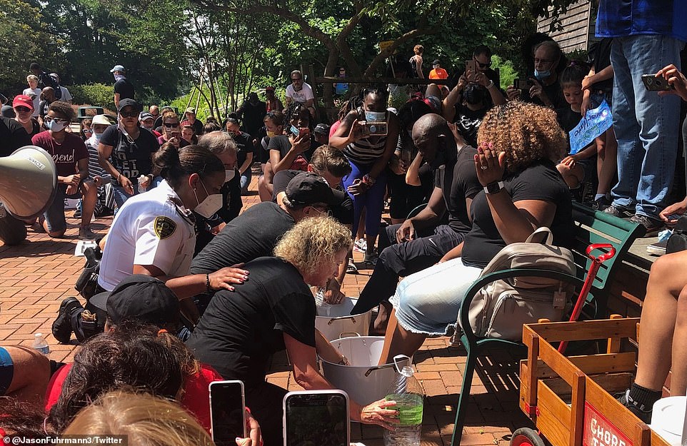 29337300-8397065-White_police_officers_and_community_members_gathered_to_wash_the-a-9_1591618965199 (1).jpg